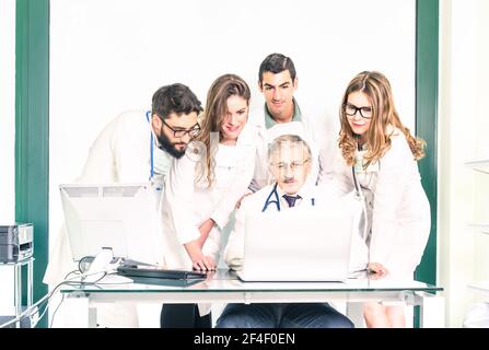 Gruppo di giovani studenti di medicina con dottore senior in salute Ambulatorio di cura - gli apprendisti medici dell'università imparano insieme con insegnante Foto Stock