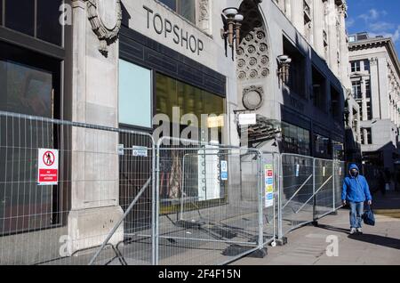 Londra, Regno Unito - 26 febbraio 2021: Barriere al di fuori dell'ex ramo di punta del Top Shop di Oxford Circus, nel centro di Londra, a pranzo soleggiato. Un uomo Foto Stock