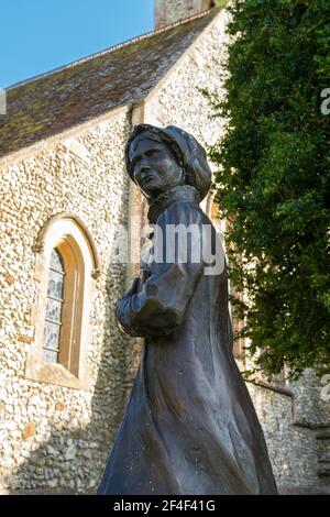 Statua del famoso autore Jane Austen fuori della chiesa di San Nicola nel villaggio Hampshire di Chawton, Inghilterra, Regno Unito Foto Stock