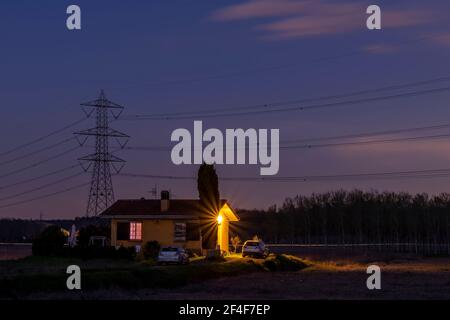 Tramonto sulla campagna toscana, su cui si può ammirare un'alta tensione pilone si blocca Foto Stock