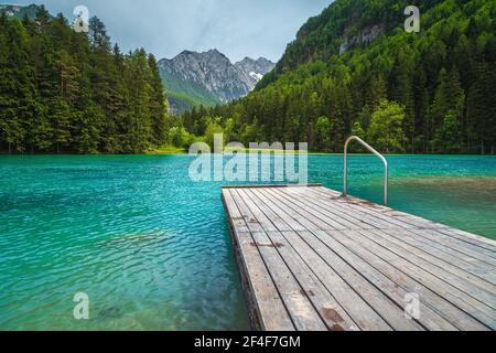 Paesaggio alpino estivo con pittoresco lago di montagna turchese. Lago di Plansarsko e pineta verde nella valle di Jezersko, Slovenia, Europa Foto Stock