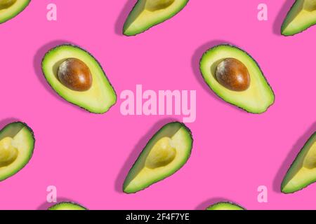 Motivo senza cuciture di frutta fresca di avocado verde mezzo isolato su sfondo rosa Foto Stock