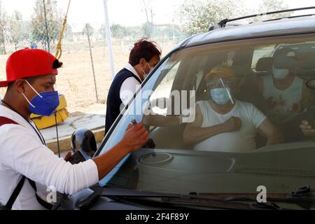 Non esclusivo: CITTÀ DI NEZAHUALCOYOTL, MESSICO - MARZO 19: Un operatore sanitario, inietta un vaccino Sinovac Covid19 ad un anziano mentre un uomo segna l'auto a. Foto Stock