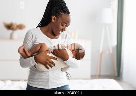 Madre afroamericana che canta ninna nanna per il bambino a dormire Foto Stock