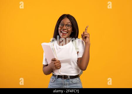 Ispirata studentessa donna nera alzando il dito, avendo idea Foto Stock