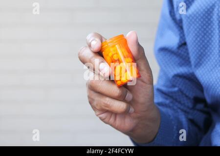 persona che tiene a mano il contenitore della pillola Foto Stock