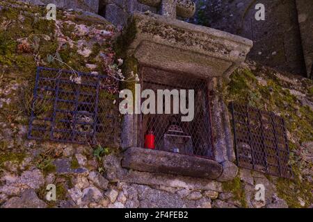 "Capilla de Almas" (Cappella dell'anima): Una piccola cappella in un muro di pietra con teschi e candele all'interno Foto Stock