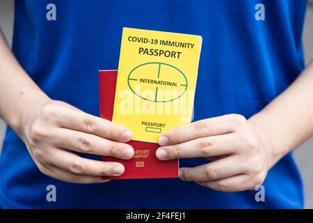 Primo piano di una persona che detiene il documento concettuale del passaporto sull'immunità del Covid-19 pronto a viaggiare Foto Stock