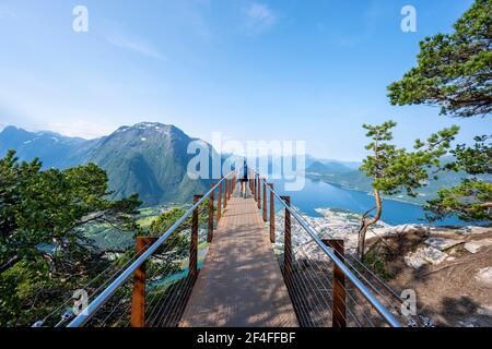 Escursionista in piedi sulla piattaforma di osservazione Rampestreken, escursioni Romsdaleggen, fiume Rauma, Romsdalfjellene montagne, Andalsnes, More og Romsdal, Norvegia Foto Stock