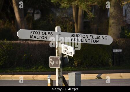 Traditional Village Road Sign in Yorkshire - Finger Post Sign - Bianco con scrittura nera - Post direzione - Yorkshire Villaggi - Regno Unito Foto Stock