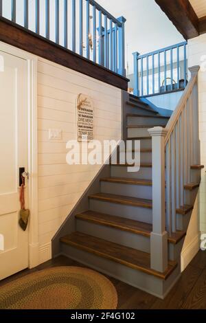 Scala per sala giochi con corrimano dipinte blu e quercia colorata scura gradini in legno all'interno di una casa in stile country Foto Stock