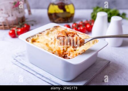 Lasagna con salsa bolognese e besciamella in forma di porzione bianca. Piatto tradizionale italiano fatto in casa. Primo piano. Foto Stock