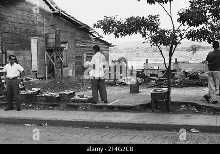 Pinalito dopo la frana con la gente che vende gli articoli nelle bancarelle del mercato di makeshift accanto alle macerie, Pinalito, Santiago de Cuba, Cuba, 1963. Dalla collezione di fotografie Deena Stryker. () Foto Stock