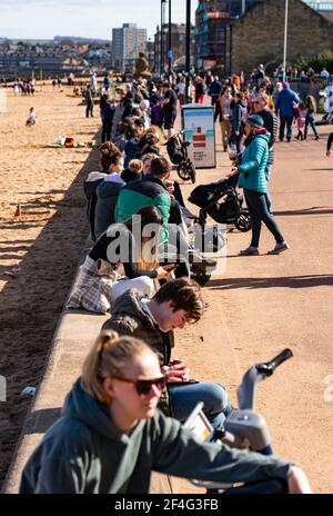 Portobello, Scozia, Regno Unito. 21 marzo 2021. Le temperature calde, i cieli blu e il sole hanno portato fuori la folla alla famosa spiaggia e passeggiata di Portobello questo pomeriggio. Nonostante la costante chiusura del covid-19, il lungomare è stato assetato di membri del pubblico. Molti caffè erano aperti e offriva cibo da asporto. Iain Masterton/Alamy Live News Foto Stock