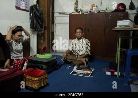 Il maestro dei burattini (dalang) Manteb Sudharsono e uno dei cantanti dell'ensemble gamelano si preparano per la performance wayang kulit 'Sudamala' nel Teatro Sasono Hinggil di Yogyakarta, Giava Centrale, Indonesia. Il tradizionale teatro delle ombre dei burattini conosciuto come wayang kulit è diffuso sulle isole di Giava e Bali in Indonesia. Ogni spettacolo di wayang kulit continua per circa otto ore attraverso la notte senza intermissioni e solo un maestro di burattini (dalang) conduce tutti i burattini proiettati su uno schermo di lino e li vocalizza con voci diverse. Anche se l'Indonesia è il Musli più popolato Foto Stock