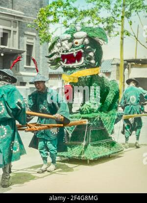 Lanterna senza titolo, colorata a mano, slide di lavoratori che trasportano la scultura del drago verde, Cina, Pechino (Cina), 1918. Dalla collezione di fotografie di Sidney D. Gamble. () Foto Stock