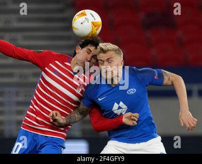 BUDAPEST, UNGHERIA - MARZO 18: Jesus Vallejo di Granada CF combatte per la palla in aria con Eirik Ulland Andersen di FK Molde durante il turno UEFA Europa League di 16 seconda tappa tra Molde e Granada alla Puskas Arena il 18 marzo 2021 a Budapest, Ungheria. Gli stadi sportivi di tutta Europa sono soggetti a rigorose restrizioni a causa del Pandemic di Coronavirus, in quanto le leggi governative in materia di distanziamento sociale vietano i tifosi all'interno dei locali, con conseguente gioco a porte chiuse. Foto Stock