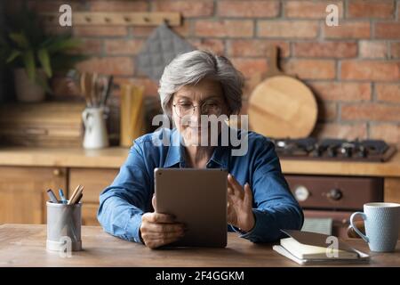 Nonna di vecchia età piace leggere e libro su tablet pc Foto Stock