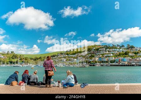 Ragazze che si divertono con un picnic sul lungomare del porto di Dartmouth, Devon, Inghilterra, Regno Unito Foto Stock