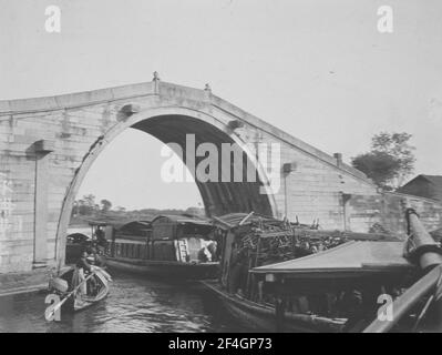 Barche che vanno sotto un ponte, Cina, Canal Grande (Cina), 1908. Dalla collezione di fotografie di Sidney D. Gamble. () Foto Stock