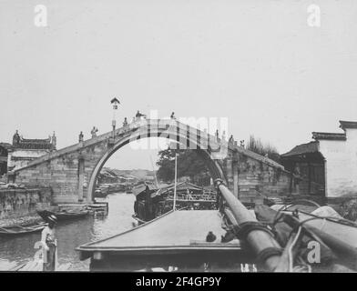 Barche che vanno sotto un ponte, Cina, Canal Grande (Cina), 1908. Dalla collezione di fotografie di Sidney D. Gamble. () Foto Stock