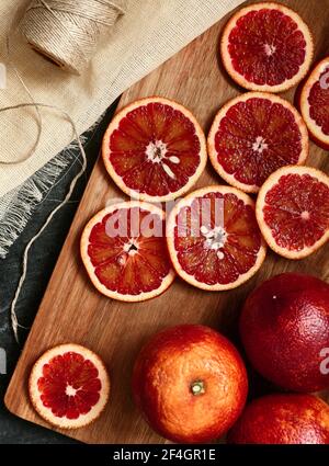 Sezione arancione di sangue rosso su una tavola di legno, vista dall'alto Foto Stock