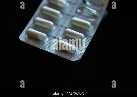Compresse in blister su sfondo nero Foto Stock