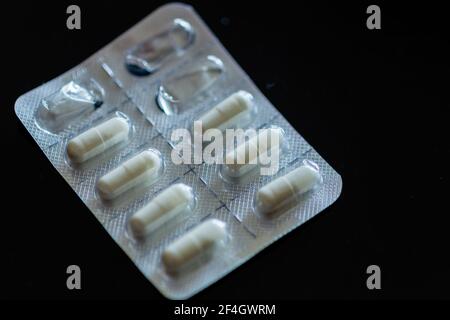 Compresse in blister su sfondo nero Foto Stock