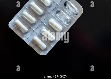 Compresse in blister su sfondo nero Foto Stock