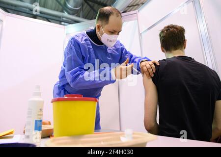 Dresda, Germania. 20 Marzo 2021. Un medico inocula un uomo contro il coronavirus in un centro di vaccinazione a Dresda, Germania, sabato. Le speranze della Germania di allentare le sue restrizioni di blocco in tempo per le vacanze di Pasqua all'inizio di aprile stanno diminuendo in mezzo ad un aumento rinnovato dei tassi di infezione la domenica. Credit: Robert Michael/dpa-Zentralbild/dpa/Alamy Live News Foto Stock