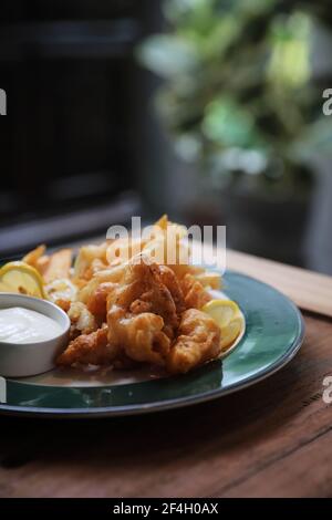 Pesce e patatine fritte pesce e patate su fondo di legno stile vintage Foto Stock