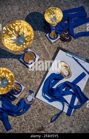 Russia.Petersburg, 05 settembre 2020: Le coppe d'oro e le medaglie dei vincitori si aspettano la consegna, i nastri blu, i risultati della gara di barche a vela, la vista dall'alto Foto Stock