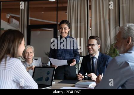 Sorridendo i dipendenti diversi discutono le idee durante la riunione di gruppo Foto Stock