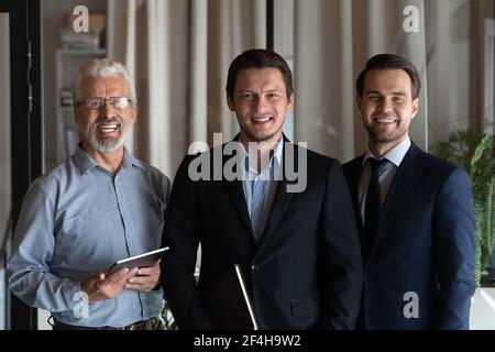 Ritratto di sorridenti diversi dipendenti maschili mostrano unità Foto Stock