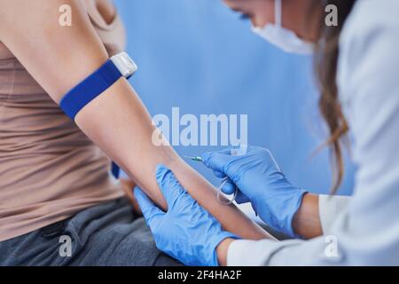 Paziente di sesso femminile con prelievo di sangue in laboratorio Foto Stock