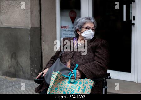 Donna in sedia a rotelle che indossa la maschera facciale. Foto Stock