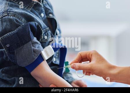 Bambino che ha prelevato il campione di sangue in un laboratorio Foto Stock