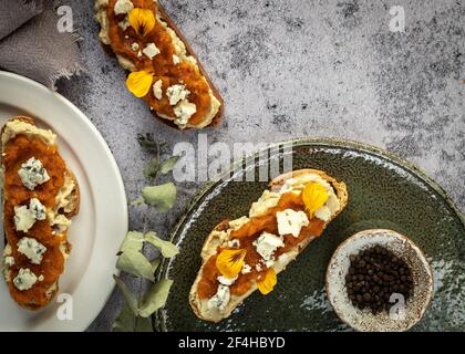 Vista dall'alto appetitosi toast freschi con marmellata e formaggio di capra servita su piatti e tavoli in marmo Foto Stock