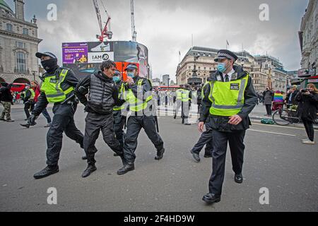 Londra, Regno Unito. 20 Marzo 2021. Un protestante è detenuto dalla polizia MET per aver violato la legge nazionale di blocco durante la manifestazione.migliaia di pr Foto Stock