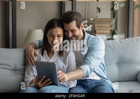 Primo piano giovane coppia felice che usa il tablet a casa insieme Foto Stock