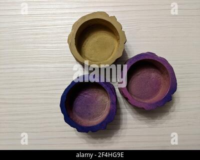 Tre vasi di cemento colorati isolati su sfondo di legno chiaro da una vista ad angolo alto Foto Stock