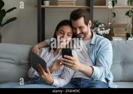Primo piano giovane coppia che si diverte con i dispositivi mobili insieme Foto Stock