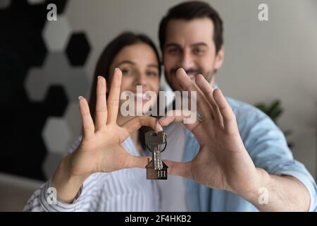 Primo piano felice giovane coppia mostrando le chiavi, primo proprio appartamento Foto Stock
