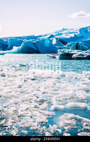 Un colpo verticale di iceberg che galleggia nella laguna glaciale di Jokulsarlon, Islanda Foto Stock