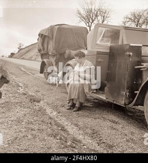 Lavoratori di piselli migranti sulla strada. Tutti i loro possedimenti mondani in auto e rimorchio. California. Febbraio 1936. Fotografia di Dorothea Lange. Foto Stock