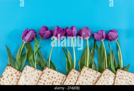 Matzos e fiori su sfondo blu. Passover (Pesach) Seder Foto Stock