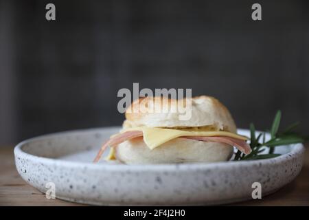 Formaggio di prosciutto di bagel in primo piano su sfondo di legno in caffetteria Foto Stock