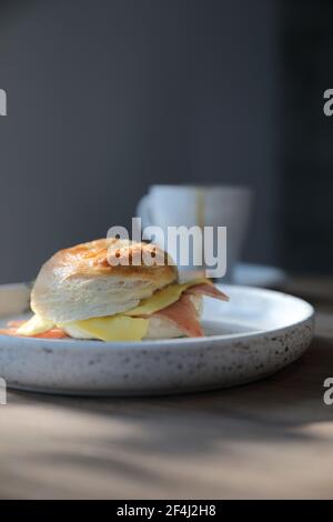 Formaggio di prosciutto di bagel in primo piano su sfondo di legno in caffetteria Foto Stock