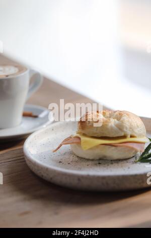 Formaggio di prosciutto di bagel in primo piano su sfondo di legno in caffetteria Foto Stock