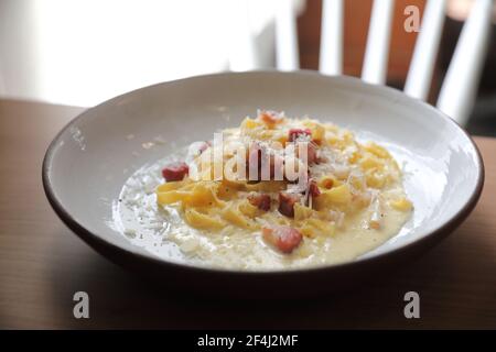 spaghetti carbonara salsa bianca con pancetta su fondo di legno dentro ristorante Foto Stock